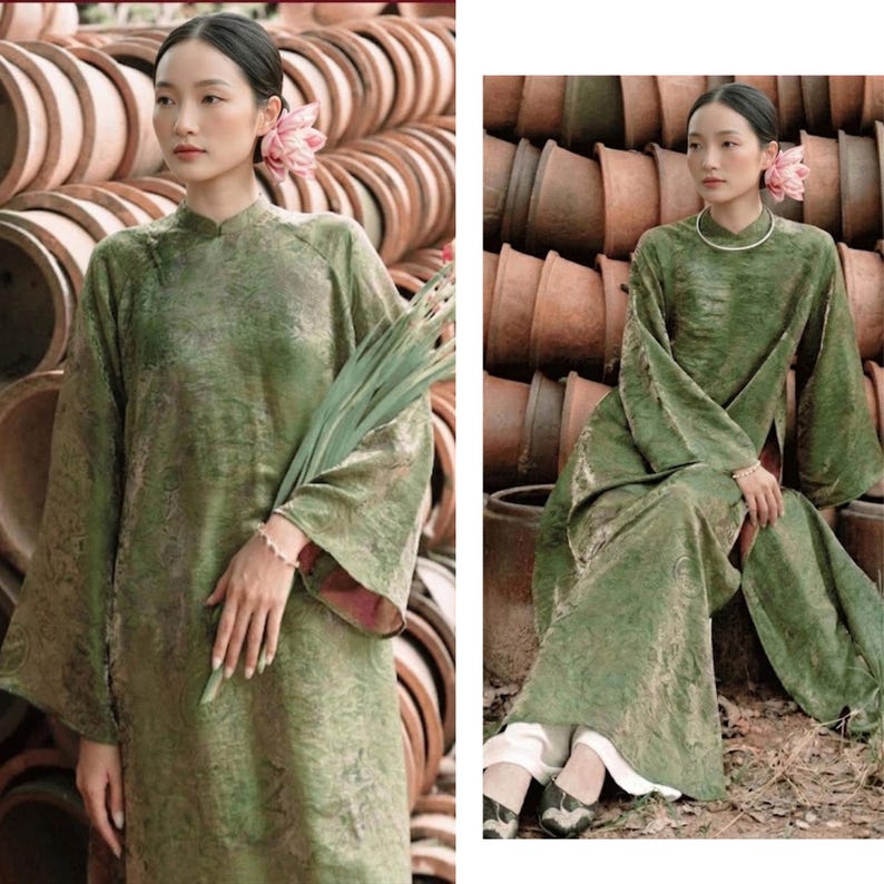 Peut inclure: Une tunique longue vert olive jusqu'aux pieds avec un motif ton sur ton subtil, dot&eacute;e d'un col montant et de manches larges. Le v&ecirc;tement est associ&eacute; &agrave; un pantalon blanc et port&eacute; avec une fleur rose dans les cheveux et un fin collier argent&eacute;.