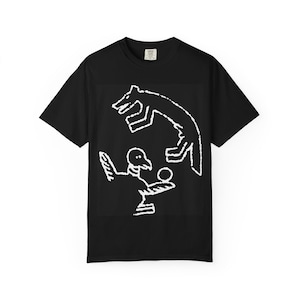 May include: Black t-shirt featuring a white graphic of a bird and a dog. The bird is holding a ball, and the dog is jumping above it. The design is a simple, line-art style. The shirt has a crew neck and short sleeves.