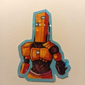 Op de afbeelding: Een sticker met een gestileerde robotillustratie. De robot heeft een rechthoekige kop en een lichaam met oranje en zwarte bepantsering. De sticker heeft een lichtblauwe omtrek en holografische accenten.