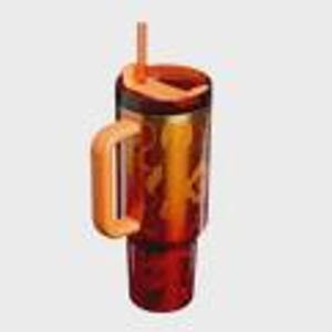 May include: A translucent amber-colored tumbler with a dark red base and a lighter orange handle. The drinkware features a matching orange lid with an integrated straw and a vertical orange graphic design on the side of the main cylindrical body.