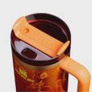 May include: A stainless steel tumbler featuring a dark orange and red floral pattern with the Stanley logo printed on the side. The tumbler includes a dark translucent lid with a light orange sliding closure and a matching light orange handle.