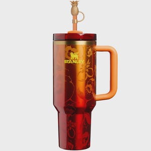 May include: A tall Stanley tumbler with a metallic red finish featuring a tonal floral pattern. It has a gold-toned rim, a solid orange handle, and a matching orange lid. A gold-colored pineapple-shaped topper is attached to the straw.
