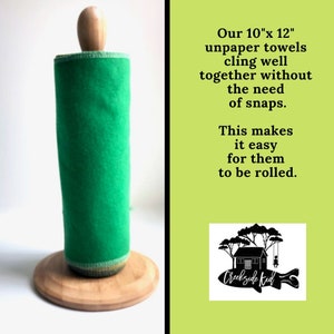 May include: A roll of bright green unpaper towels on a wooden holder. The text reads: Our 10"x 12" unpaper towels cling well together without the need of snaps. This makes it easy for them to be rolled. A logo shows a house and the text Creekside Kid.