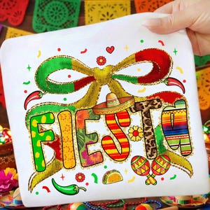 Puede incluir: Camiseta blanca con la palabra "FIESTA" en letras coloridas y decorativas. El diseño incluye un sombrero, maracas, chiles y un lazo. La camiseta está decorada con detalles de purpurina dorada e imágenes festivas.