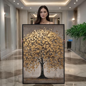 May include: A framed canvas art piece featuring a tree with gold-colored leaves. The tree's trunk and branches are dark against a neutral background. The artwork is displayed in a well-lit hallway.