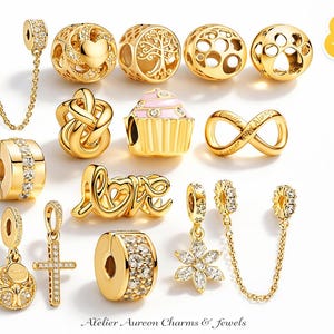 Puede incluir: Una colección de abalorios y joyas doradas, que incluyen cuentas, colgantes y una cadena de seguridad. Los diseños incluyen corazones, un árbol de la vida, una magdalena, un símbolo de infinito y la palabra "LOVE". Algunos abalorios están adornados con cristales transparentes.