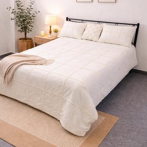 Könnte beinhalten: Eine weiße Keramiktasse mit schwarzem Henkel und dem Text "But First, Coffee" in fetter, schwarzer Schrift. Die Tasse steht vor einem verschwommenen Hintergrund, der eine gemütliche Umgebung suggeriert.