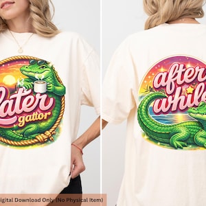 May include: Cream-colored t-shirt featuring a cartoon alligator design. The front graphic says "Later gattor" with an alligator wearing sunglasses and holding a mug. The back graphic says "after while" with an alligator.