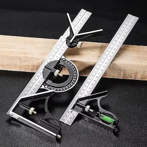 May include: A set of black and silver combination squares and protractor with measurement markings. The tools are placed on a wooden plank and a black surface. The protractor has a circular scale.