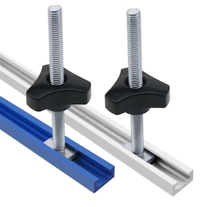 May include: Two woodworking T-track hold-down clamps. Each clamp has a black knob, a silver threaded rod, and a metal plate. The T-tracks are blue and silver.