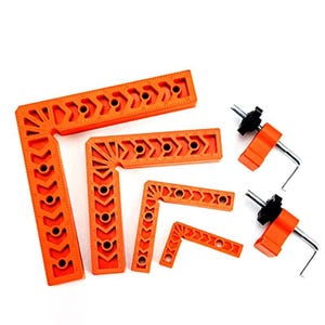 Peut inclure: Ensemble d'équerres et de serre-joints orange. Les équerres présentent des trous et des découpes en forme de flèche. Deux serre-joints avec des composants noirs et orange et des clés hexagonales sont également inclus. Outils pour le travail du bois et la construction.