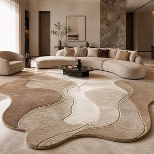 Könnte beinhalten: Ein modernes Wohnzimmer mit einem großen, abstrakt geformten Teppich in Beige- und Brauntönen. Das Design des Teppichs ergänzt ein geschwungenes Sofa und einen runden Sessel und schafft ein stilvolles Interieur.