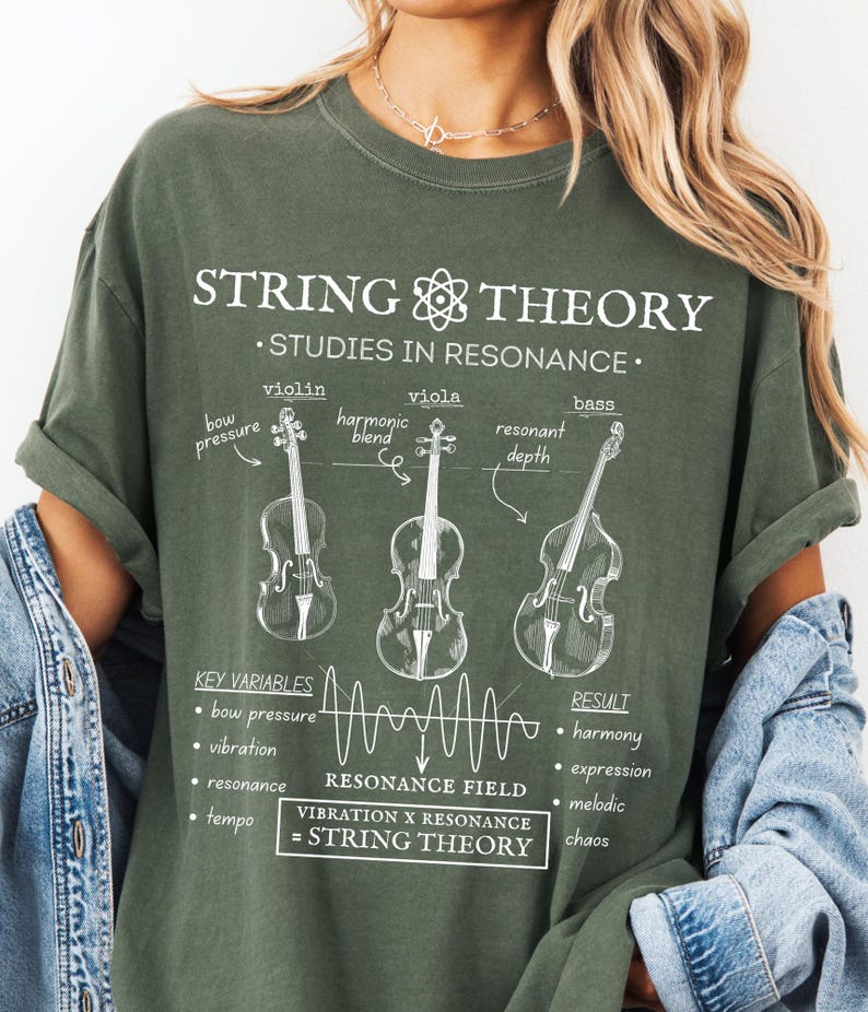 May include: An olive green t-shirt featuring a white graphic print titled STRING THEORY. The design includes illustrations of a violin, viola, and bass with labels like bow pressure and resonant depth, plus a resonance field wave and text equations.