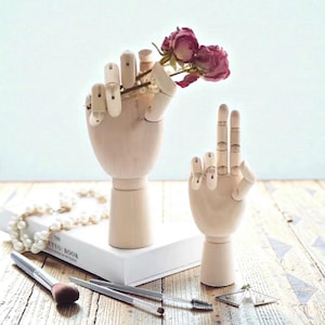 Puede incluir: Un juego de tres botes de cerámica con tapas. Los botes son blancos con un estampado floral azul. El más grande mide 20 cm de alto, el mediano 15 cm y el más pequeño 10 cm.