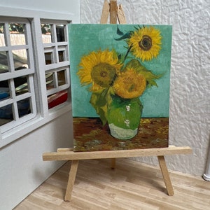 May include: A painting of three sunflowers in a green vase on a wooden table. The sunflowers are yellow with brown centers and green leaves. The background is a light blue color.