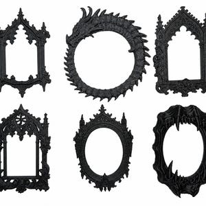 May include: A collection of six black decorative frames featuring intricate designs. The set includes two pointed arch frames, one circular frame shaped like a coiled dragon, one oval frame with ornate detailing, and one oval frame with sharp teeth.