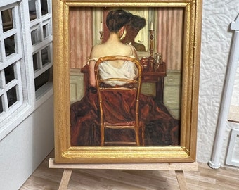 May include: A framed painting of a woman sitting in front of a vanity, looking into a mirror. The woman is wearing a white dress and a red skirt. The painting is set on a wooden easel.