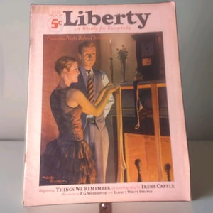 May include: A vintage Liberty magazine cover from December 24, 1927, featuring an illustration of a person in a dark dress and a person in a vest and tie standing by a fireplace. The text reads Liberty, A Weekly for Everybody, and Things We Remember.