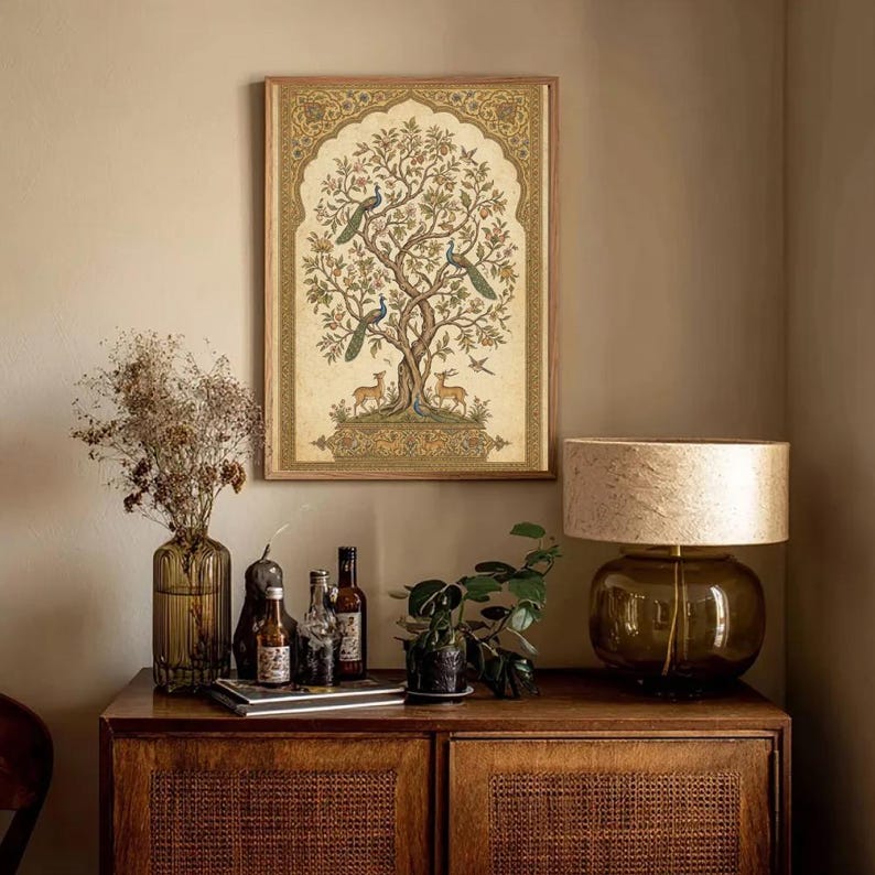 May include: A rectangular wall art print featuring a detailed illustration of a large tree with peacocks and deer, enclosed in an ornate golden archway border. The artwork displays a muted color palette of gold, brown, and green tones on a cream background.