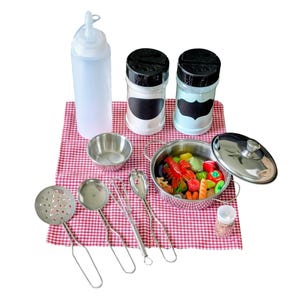 May include: A play kitchen set with a variety of toy cooking tools and ingredients. Includes a stainless steel pot with lid, a strainer, a ladle, a whisk, and a small bowl. Also includes a squeeze bottle, spice shakers, and toy vegetables.