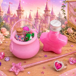 Könnte beinhalten: Ein rosa Prinzessinnen-Set mit einer sternförmigen Flasche, einem Kessel, einem Zauberstab und einem Ring mit einem herzförmigen Edelstein. Der Hintergrund zeigt ein Schloss, ein Banner mit "Princess" und eine Krone. Der Kessel enthält einen kleinen Frosch.