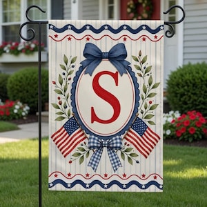 May include: A garden flag featuring a patriotic design with the letter "S" in red. The flag includes American flags, blue bows, and a scalloped oval frame. The background has vertical stripes and a border with stars.