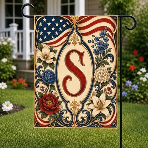 May include: A decorative garden flag featuring an American flag design with the letter "S" in the center. The flag has a cream-colored background with red, white, and blue floral accents and a black metal stand.
