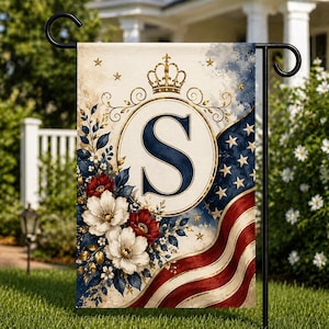 May include: A garden flag with a patriotic design, featuring the letter "S" in a navy blue circle, a gold crown, and floral accents. The flag incorporates elements of the American flag with red, white, and blue colours.