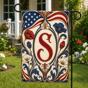 May include: A decorative garden flag featuring an American flag design with the letter "S" in the center. The flag has red, white, and blue colors with floral accents. The flag is displayed on a black metal stand.