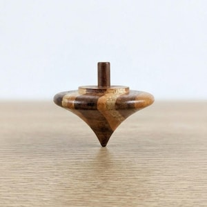 Puede incluir: Un juego de tres tazas de cerámica con un acabado moteado y mate. Las tazas son de color crema, gris claro y gris oscuro. Cada taza tiene un diseño simple y minimalista.