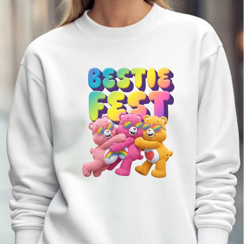 May include: White sweatshirt featuring the text "BESTIE FEST" in colorful bubble letters above three cartoon bears wearing sunglasses. The bears are pink, magenta, and yellow, with rainbow accents.