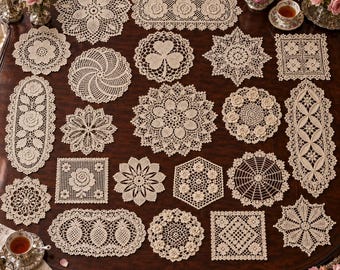 May include: A collection of twenty-two cream-colored crocheted doilies in various shapes including round, square, oval, and hexagonal designs. Each piece features intricate openwork patterns, floral motifs, and geometric borders.