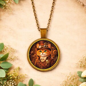 May include: A round pendant necklace with a steampunk cat design. The pendant features a detailed illustration of an orange cat wearing a top hat and goggles, set against a backdrop of gears and machinery. The chain and pendant frame are bronze-colored.