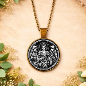 May include: A bronze chain necklace with a circular pendant. The pendant displays a monochrome illustration of three robed figures, one with scissors. The figures are in a circle, with a detailed border.