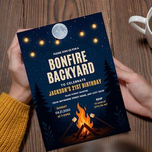 Könnte beinhalten: Eine dunkelblaue Einladung mit dem Text "Bonfire Backyard" und "Jacksons 21. Geburtstag". Das Design zeigt eine Lagerfeuer-Illustration, einen Vollmond, Lichterketten und Kiefern. Die Einladung wird von einer Person gehalten.