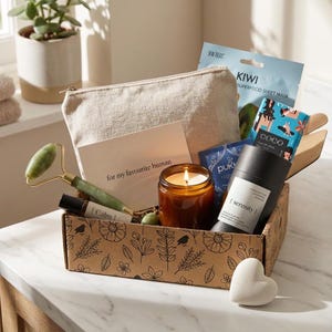 May include: A gift box filled with self-care items. Includes a jade roller, candle, face mask, and a cosmetic bag. The box is decorated with floral patterns and the text "for my favourite human".