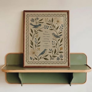 Puede incluir: Una impresión rectangular enmarcada que muestra tres pájaros azules, ramas florales y bayas sobre un fondo crema. El texto dice: His Mercies are new every morning Lamentations 3:23. La impresión está dentro de un marco de madera marrón.