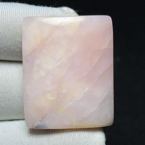 Könnte beinhalten: Eine weiße Keramik-Tasse mit schwarzem Henkel und dem Text "But First, Coffee" in schwarzer, handschriftlicher Schrift. Die Tasse steht auf einer weißen Oberfläche.