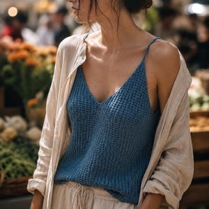 Peut inclure: Un débardeur en tricot bleu sans manches avec un col en V et de fines bretelles, porté sous une chemise beige à manches longues boutonnée et associé à un pantalon beige à cordon de serrage. Le haut présente un motif en maille texturée.
