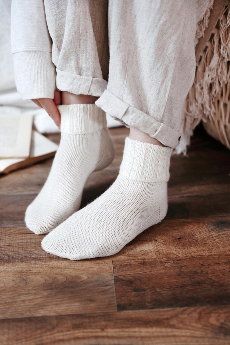 Knitting pattern pages close-up, basic socks knit instructions detail. basic socks knitting pattern. fold over socks knit pattern. easy knit women socks. top down knit socks pattern. cream white knit socks pattern. beginner socks knitting pattern. adult women knit socks pattern. classic knit socks.