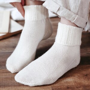 Knitting pattern pages close-up, basic socks knit instructions detail. basic socks knitting pattern. fold over socks knit pattern. easy knit women socks. top down knit socks pattern. cream white knit socks pattern. beginner socks knitting pattern. adult women knit socks pattern. classic knit socks.