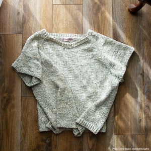 A basic knitted tshirt, The Classic Tee, is laid on the floor. This simple knit tee features a raglan construction and simple knit stitches. The easy knit tee looks lightweight and comfortable to wear as a knit summer top.
[sweater knit patterns]