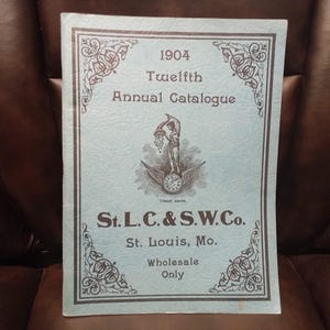 May include: A light blue paper catalog cover with a decorative border and the text "1904 Twelfth Annual Catalogue" and "St. L. C. & S.W.Co. St. Louis, Mo. Wholesale Only".