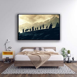 Puede incluir: Una impresión artística enmarcada representa una silueta de figuras caminando por una montaña, con un caballo a la cabeza. El fondo presenta un cielo nublado y montañas. La obra de arte se exhibe sobre una cama en un dormitorio.