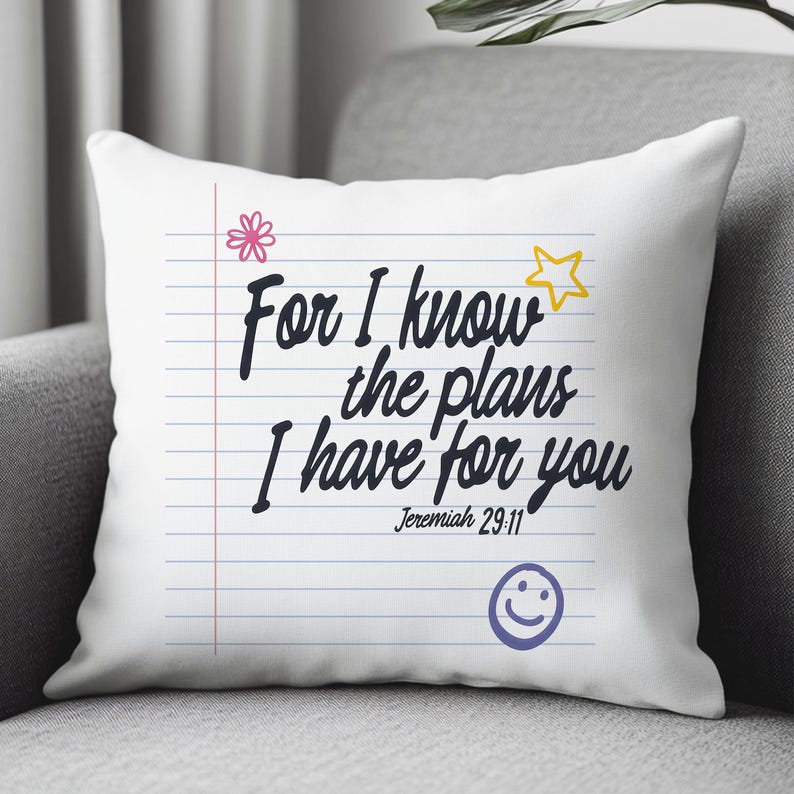 K&ouml;nnte beinhalten: Ein wei&szlig;es quadratisches Kissen mit einem linierten Notizbuch-Design, blauen horizontalen Linien und einem roten vertikalen Rand. Der Text lautet, For I know the plans I have for you, Jeremiah 29:11, mit einer rosa Blume, einem gelben Stern und einem lila Smiley.