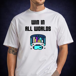 Może przedstawiać: Biała koszulka z napisem "WIN IN ALL WORLDS" czarnymi literami. Poniżej znajduje się grafika gogli wirtualnej rzeczywistości i krajobrazu miejskiego. Gogle VR są jasnoniebieskie, a krajobraz miejski zawiera budynki w kolorze żółtym, fioletowym i niebieskim.