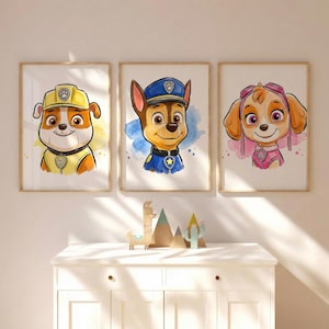 May include: Three framed watercolor prints featuring cartoon dog characters. The prints showcase the characters in vibrant colors, with each dog wearing a uniform or accessories. The artwork is displayed above a white cabinet with decorative wooden figurines.