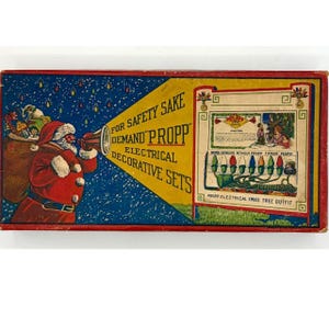 May include: A vintage rectangular cardboard box for Propp electrical decorative sets. The box features a red border, a blue background with yellow light accents, and an illustration of Santa Claus holding a megaphone with the text For Safety Sake Demand Propp Electrical Decorative Sets. A white panel displays a Propp Christmas tree light outfit illustration.