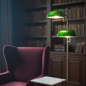 May include: A library setting with a burgundy armchair, a small marble-topped table, and a brass floor lamp with two green glass shades. The background features a dark wooden bookcase filled with books, creating a cozy and classic ambiance.