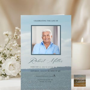 May include: A memorial card featuring a photograph of a man in a blue shirt, with the text "Celebrating the Life of Robert Miller". The card includes dates and service details, set against a waterscape background.
